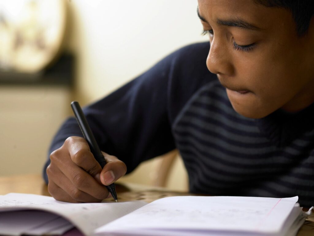 child writing something on paper