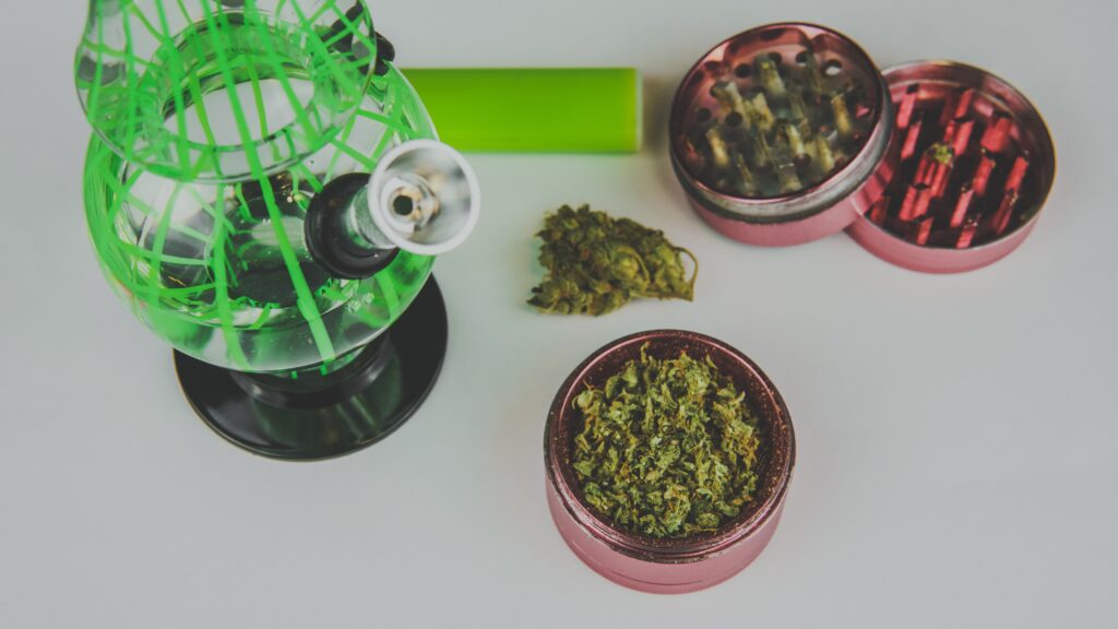 medical marijuana buds with bong and grinder close