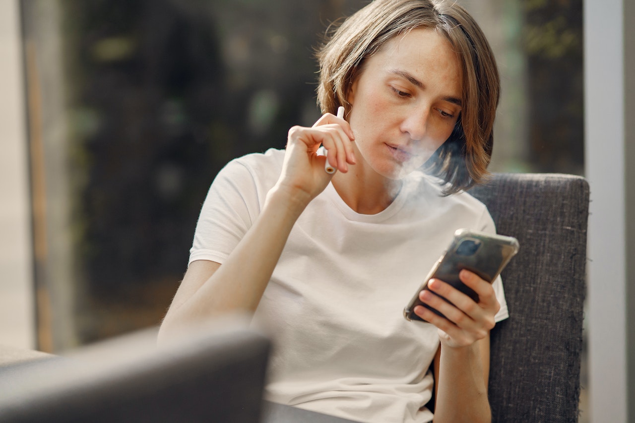 Woman holding vape pen with medical cannabis for pain relief
